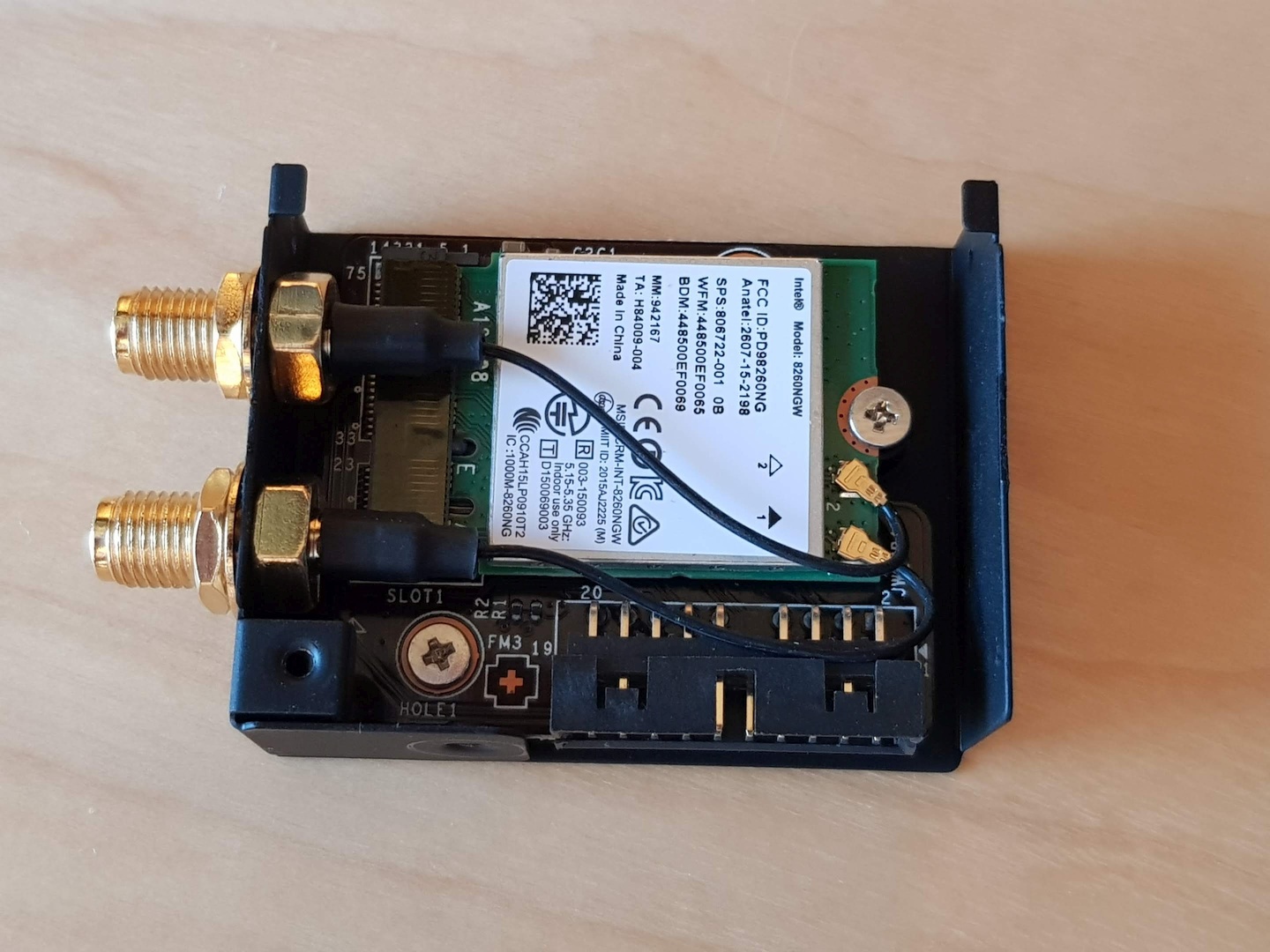 A photo the WiFi/Bluetooth module without the front cover. Inside there's indeed just an adapter from the weird PCI express header into a normal M.2 with Intel's WiFi/Bluetooth card connected.